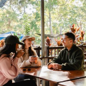 People sitting at table with cups and drinking and laughing